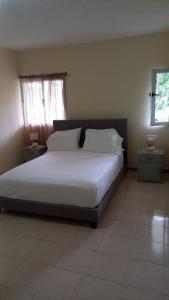 Rui VazRecanto da Montanha的一间卧室配有一张带白色床单的床和一扇窗户。