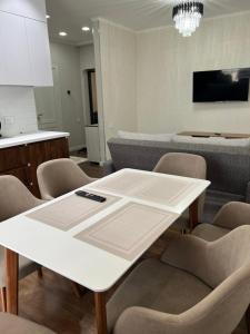 YalanghochУютная квартира в элитном ЖК NRG的一间配备有白色桌椅的用餐室