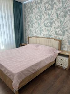 YalanghochУютная квартира в элитном ЖК NRG的一间卧室设有一张床和一面墙