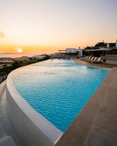 米克诺斯城Alia Luxury Villa Mykonos的一座享有日落美景的大型游泳池