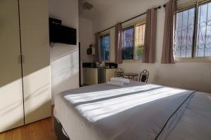 海法Zimmer Garden的卧室设有白色大床和窗户。