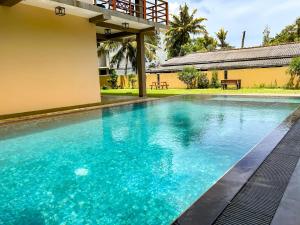 韦利格默Tropical Villa - Weligama的蓝色水屋前的游泳池