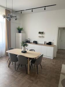 德布勒森Modern új lakás a belvárosban的厨房里配有餐桌和椅子