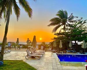 卡塔赫纳Morros Zoe - Beautiful Apartment on Manzanillo Beach的一个带游泳池和椅子的度假村,享有日落美景