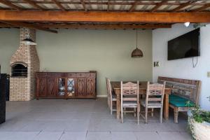 尼泰罗伊Casa incrível com 04 suítes - 5 min de Itacoatiara的庭院配有桌椅和电视。