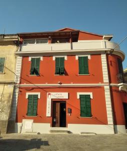 菲维扎诺Alla Porta Di Sotto B&B的一条橙色的建筑,在街上有绿色百叶窗