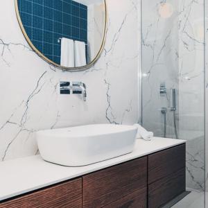 普雷韦扎BLUE LUXURY SUITES的白色的浴室设有水槽和镜子