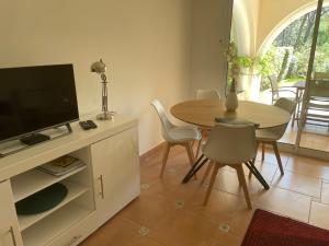 圣拉斐尔2 pièces Saint Raphael rénové, classé 4 étoiles, 100 m plages, piscine, tennis, parc, terrasse, jardin privatif的客厅设有餐桌和电视