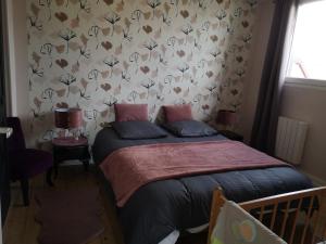 StaffelfeldenLe logis du mineur Chez Agnès et Joël的一间卧室配有一张带花卉壁纸的床