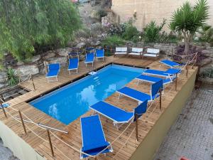 夏卡Holiday Beach Lumia的一个带蓝色椅子的游泳池和一个游泳池