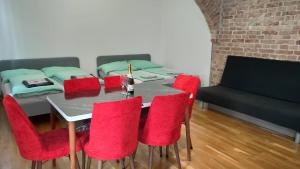 维也纳CozyNite Premium Apartment Stadthalle的一间带桌子和红色椅子的用餐室