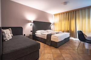 卢布尔雅那Ljubljana Resort Hotel & Camping的酒店客房,配有床和沙发