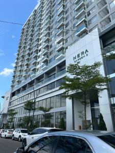 顺化Chi Homestay Nera Garden Huế的一座大型建筑,前面有汽车停放