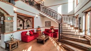 莱瓦镇Maria Bonita Hotel的一间带楼梯和红色沙发的客厅
