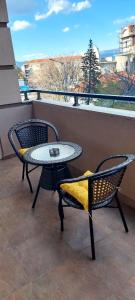 斯特鲁米察Sandras Apartment的庭院设有两把椅子、一张桌子和一扇窗户。