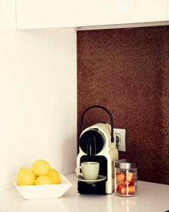 赫罗纳THE RIVERSIDE LODGE Cozy and spacious apartment的厨房柜台配有咖啡壶和一碗水果