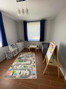 格涅维诺Apartament Nova Gniewino的一间儿童房,配有一张婴儿床和一张黑板