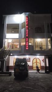 西里古里Bikash Bhawan Lodge的夜间停在大楼前的汽车