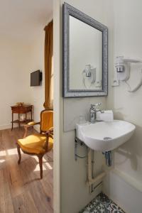 布鲁瓦法国和盖斯酒店的一间带水槽、镜子和椅子的浴室