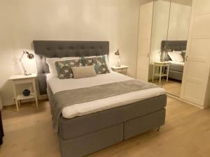 桑内斯Divine Seaview Terrace的一间卧室配有一张大床和两张桌子