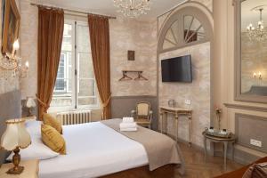 布鲁瓦法国和盖斯酒店的酒店客房设有一张大床和一台电视机。