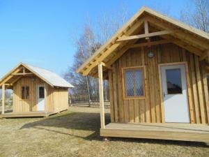 帕普Pūķarags - Kempings的两座小木头建筑,坐在草地上