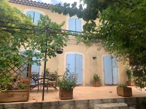 马赛Studio L Oustaou的一个带蓝色门和桌椅的庭院