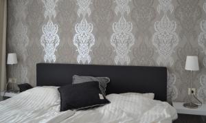 维林根Kurpark Maisonnette Willingen的一间卧室配有一张带黑色床头板和壁纸的床。