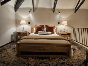 德尔斯特鲁姆Tarry-Stone Cottages的一间卧室配有一张大床,两台桌子上放着两盏灯