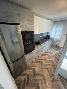 陶格夫匹尔斯AIVI apartments的厨房配有不锈钢冰箱和木地板