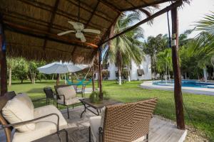 切图马尔玛雅秘密精品酒店 的一个带椅子和遮阳伞的庭院和一个游泳池