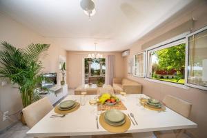阿尔戈斯托利翁Gaia Residences with lush garden and pool的一间配备有白色桌椅的用餐室
