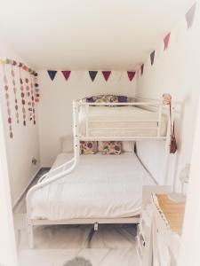 EsteponaMoraleja, habitación en bajos con jardín en Estepona的卧室配有两张双层床,墙上挂着旗帜