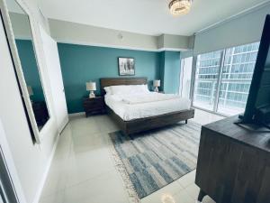 迈阿密Sun&Sea IconBrickell Unit的一间带蓝色墙壁、一张床和电视的卧室