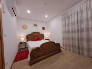 恩特雷里奥斯Burguesinha AL Entre-os-Rios的一间卧室配有一张带两盏灯的大木床。