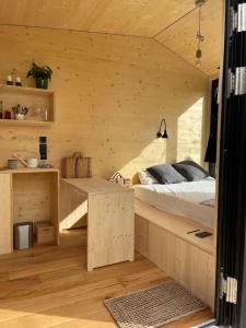 Cabana auf dem Biohof Hornen的一间卧室配有一张床和一张书桌