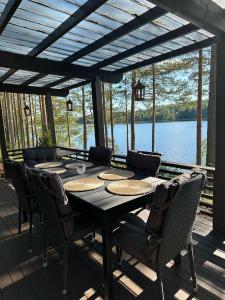 约恩苏Cityvilla on the shore of Lake Haapajärvi的湖景甲板上的桌椅