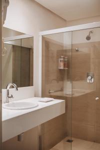 大坎皮纳塞拉诺酒店的一间带水槽和玻璃淋浴的浴室