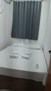 贝伦Hotel Porto da Lua Belém的蓝色窗帘的房间的一张床位