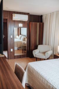 大坎皮纳塞拉诺酒店的一间卧室配有一张床、一把椅子和镜子