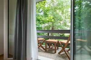 圣加仑Inn Joy Apartments - Sankt Gallen West的阳台配有桌椅,可眺望窗外