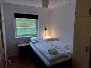 FunningsfjørðurFjord Guesthouse的窗户客房内的一张大床