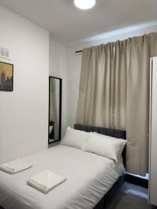 伦敦Ivy House Hotel的一间卧室配有一张带白色床单的床和一扇窗户。