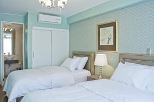 特鲁希略阿沃精品酒店的蓝色墙壁客房的两张床
