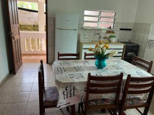 乌巴图巴APTOS FAMILIA com AR CONDICIONADO UBATUBA Praia Pereque Acu的厨房配有一张桌子,上面放着花瓶