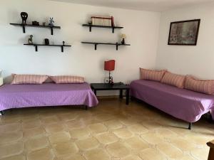 里奥马里纳Villa Isa的一间设有两张床、一张桌子和书架的房间
