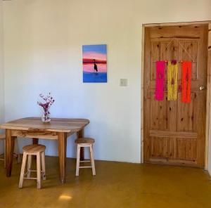 圣卡塔利娜岛Hostal Aguas Verdes的一个带门的房间里一张桌子和两张凳子