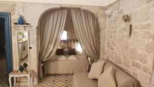 奥斯图尼Casa Mirabilis 44的一间卧室配有一张带窗帘和桌子的床