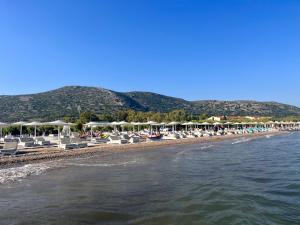 ChóraHoliday Oasis with private patio and Hammam-style bath in Chora-Pithagoreo, Samos Island的海滩上设有椅子和遮阳伞,水面