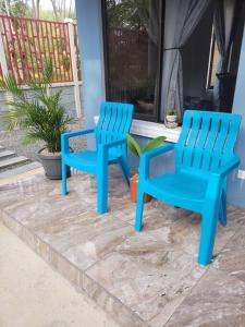 坦波Casa en Playa Tambor - A 5 minutos de la playa的两把蓝色椅子坐在房子旁边